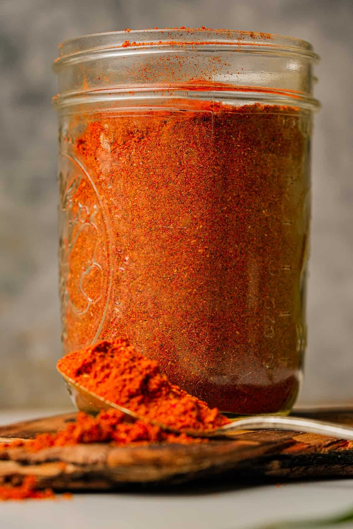 Achar ka masala in a jar on a wooden table.