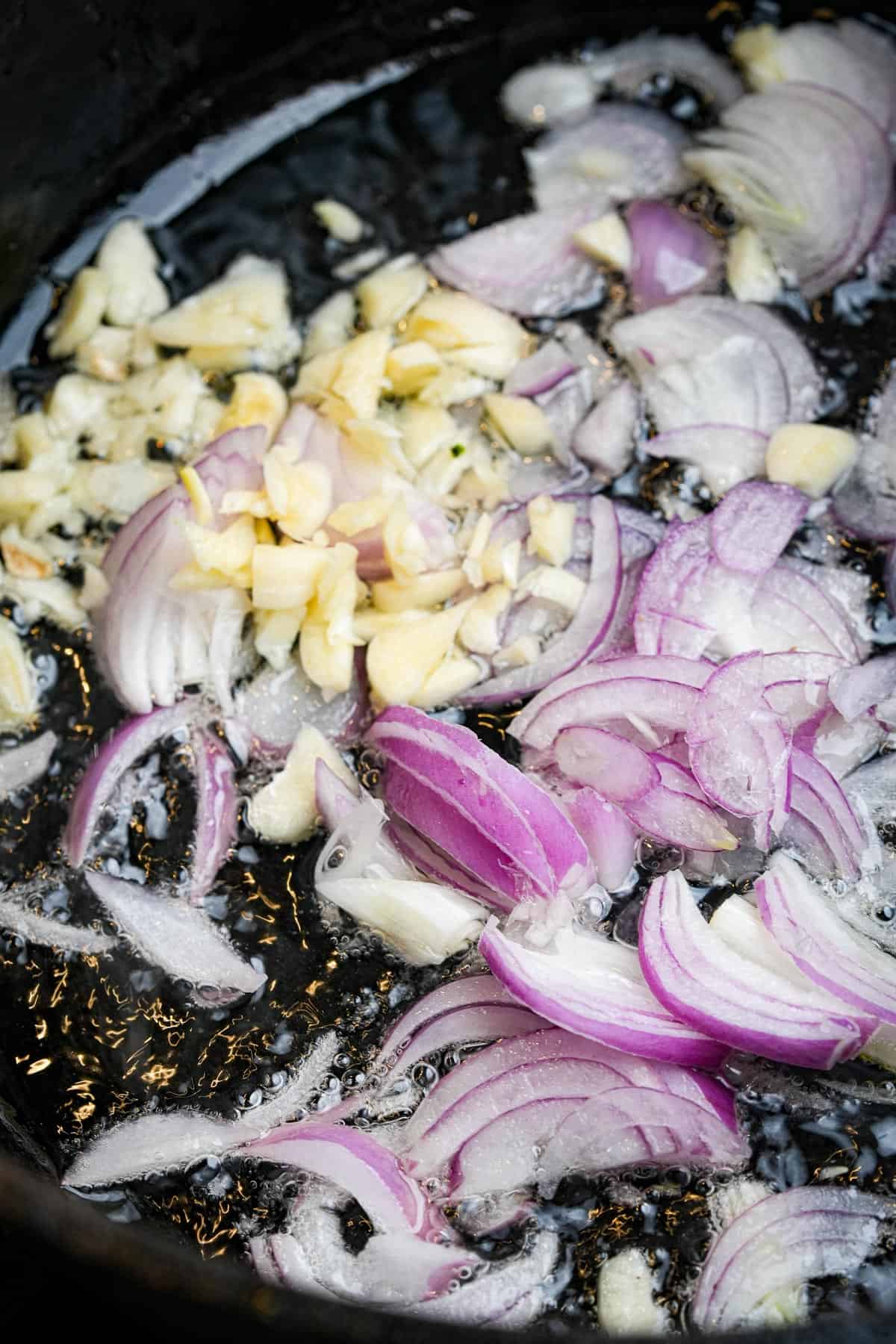 Onions and garlic being cooked in a pan.