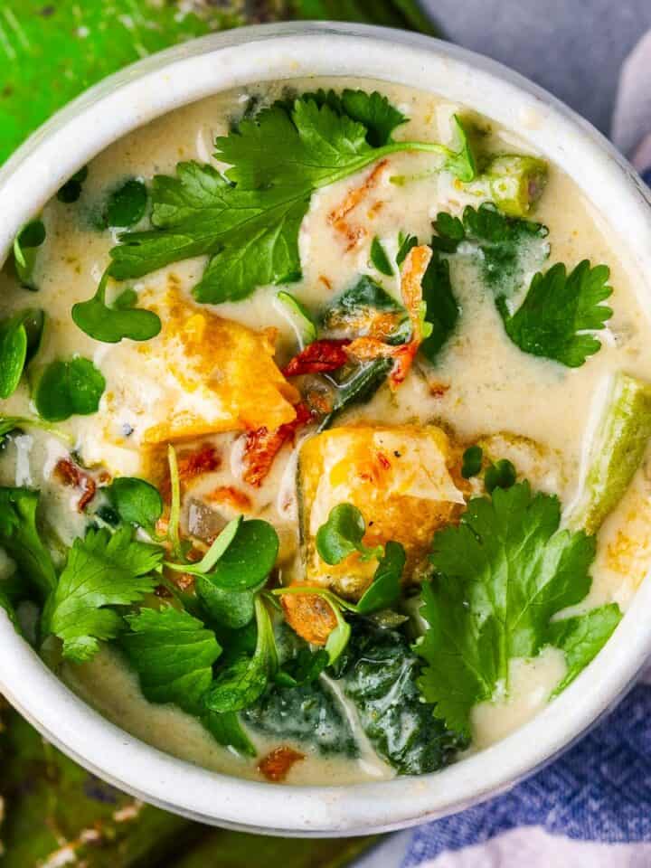 A bowl of Ginataang Kalabasa with bread on the side.