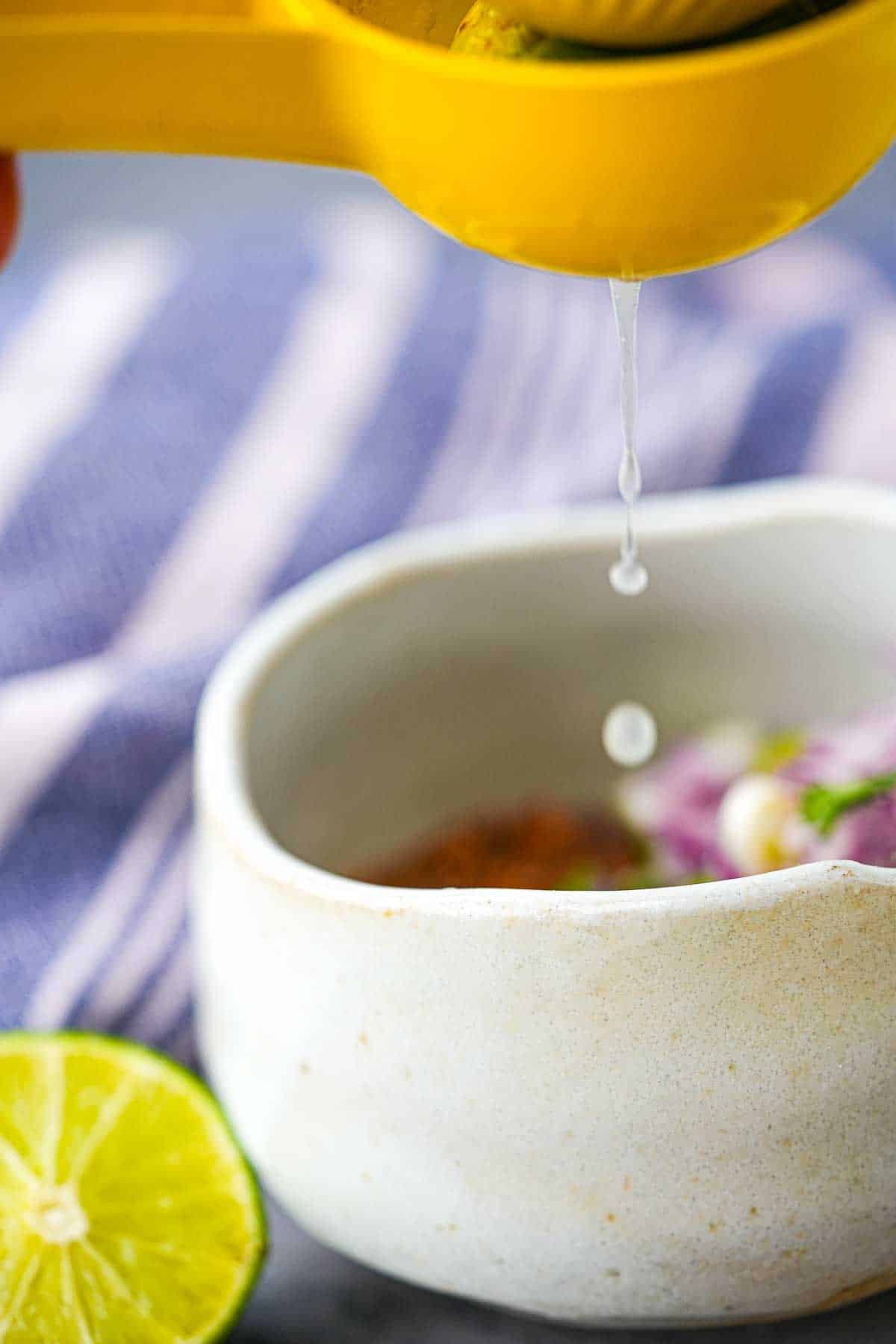 A person pouring lime juice into a bowl.