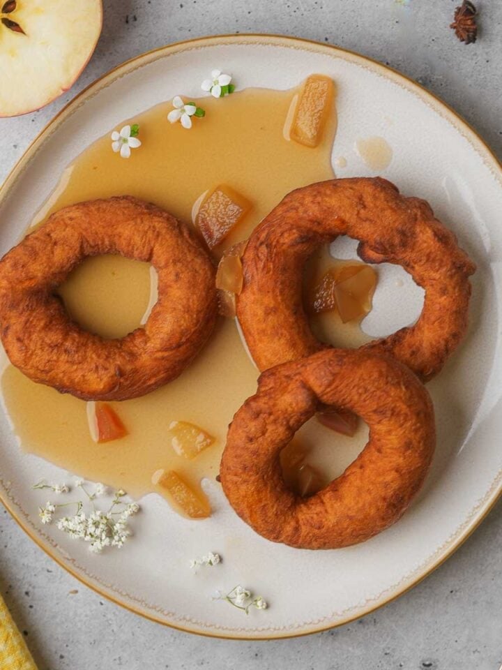 Picarones with chamomile apple syrup on a plate.