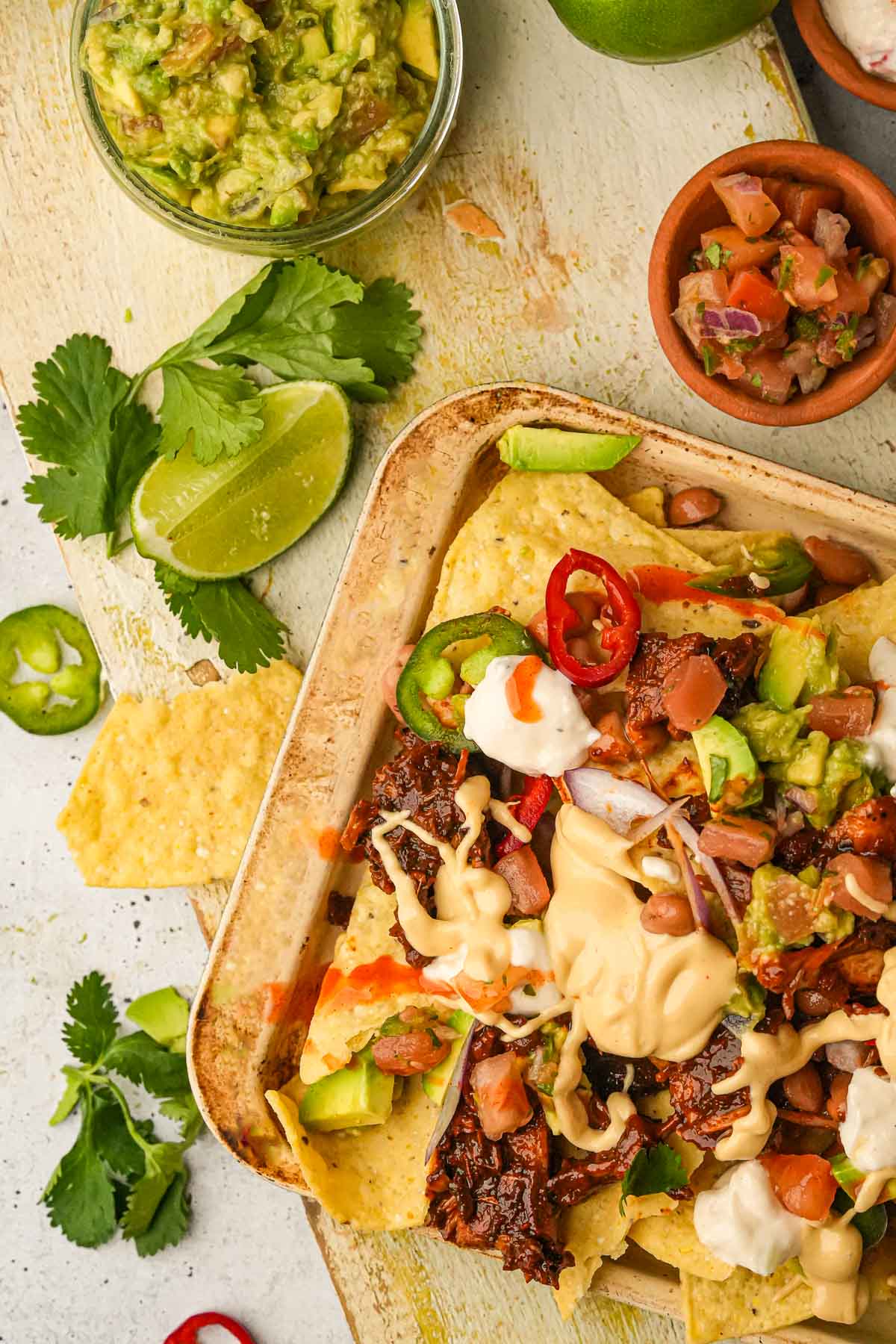 Vegan nachos with guacamole, vegan nacho cheese and sour cream.