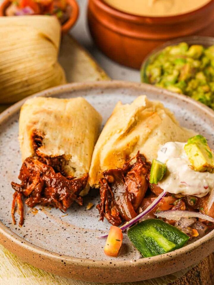 Vegan tamales on a plate with guacamole and guacamole.