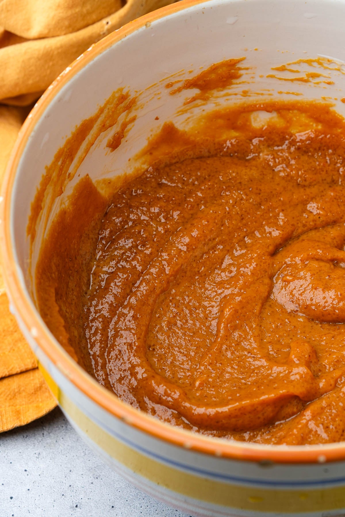 A bowl filled with a the wet ingredients for Vegan Pumpkin Muffins