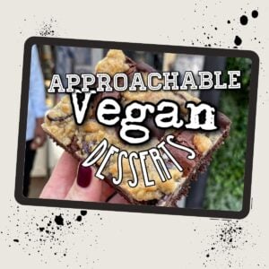 A hand holding a square piece of dessert with text overlay: "Approachable Vegan Desserts.
