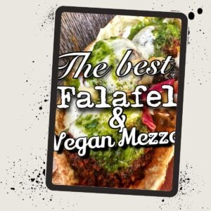 Close-up of a falafel wrap with text overlay reading "The best Falafel & Vegan Mezzo" on a visually styled background.